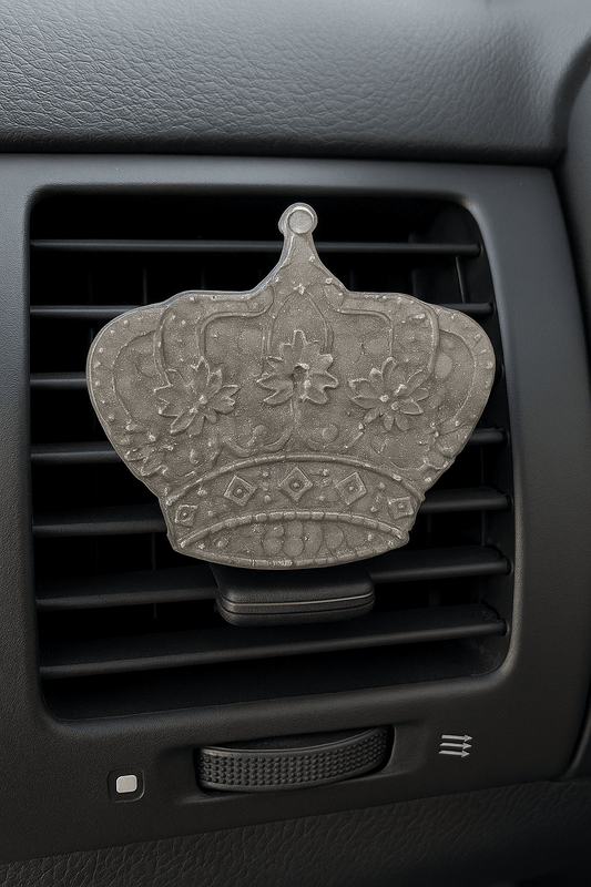 Decorative car air freshener shaped like a crown on a car vent.