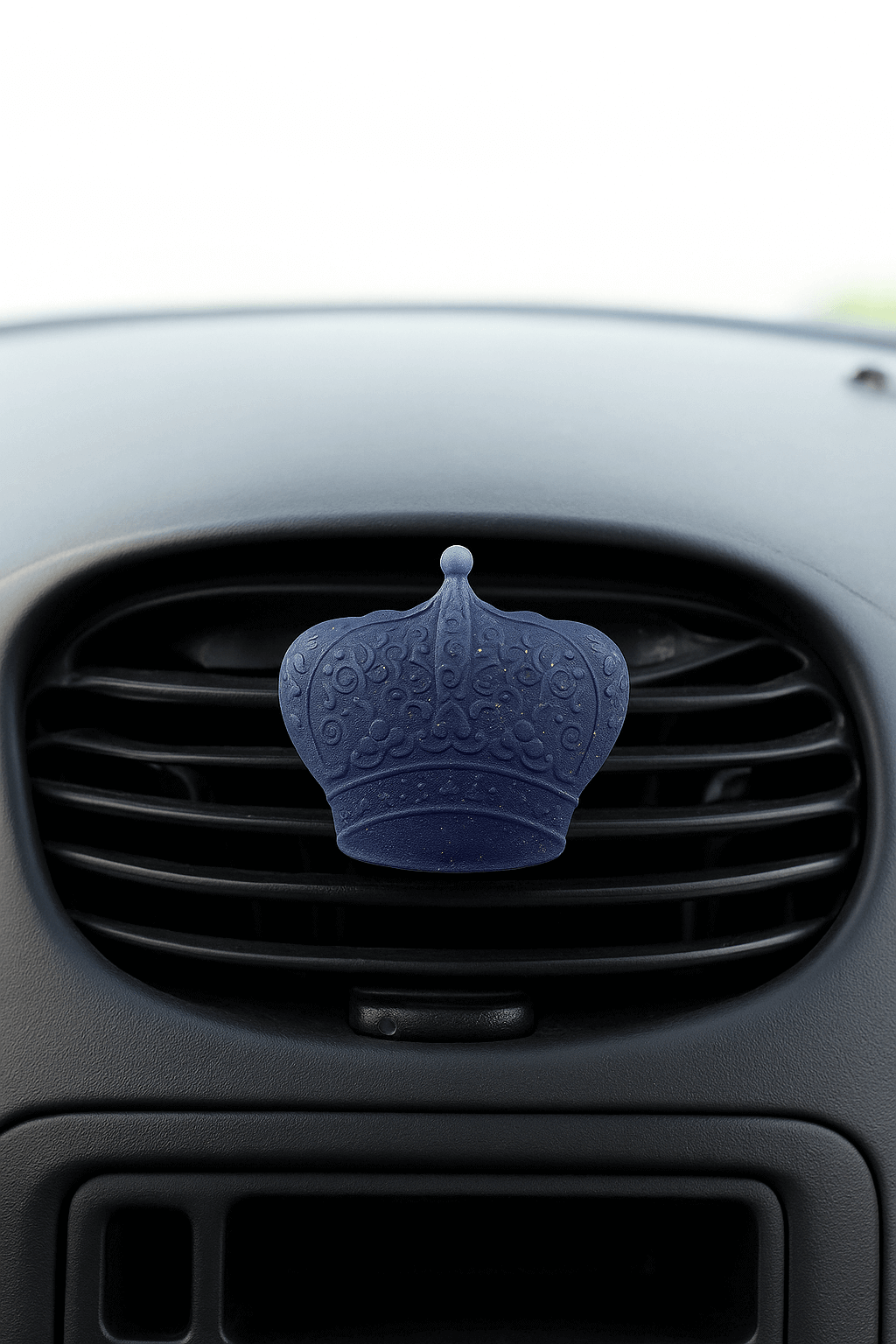 Blue car air freshener shaped like a crown on a car vent.