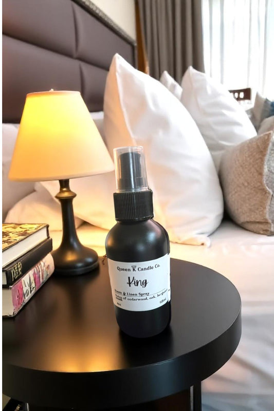 Black spray bottle labeled 'Kingsley' on a nightstand with a lamp and books in the background.