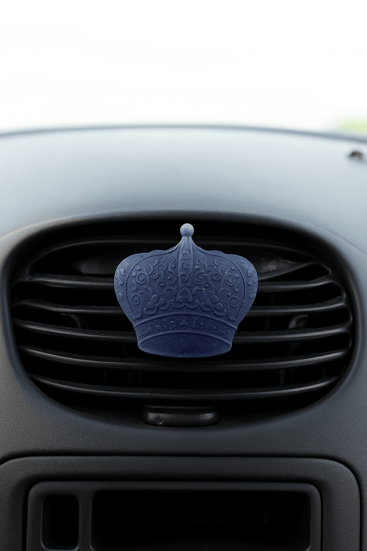 Blue car air freshener shaped like a crown on a car vent.