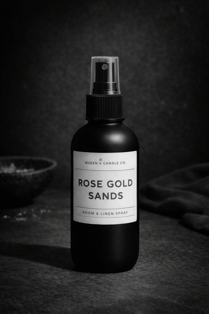 Black room & linen spray bottle labeled 'Rose Gold Sands' on a dark background