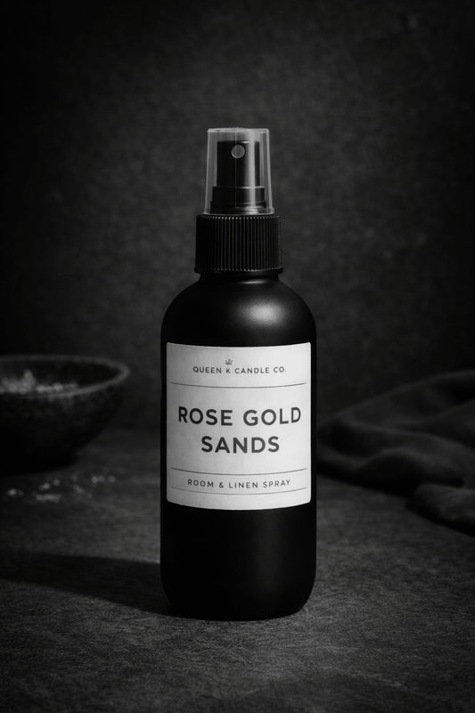 Black room & linen spray bottle labeled 'Rose Gold Sands' on a dark background