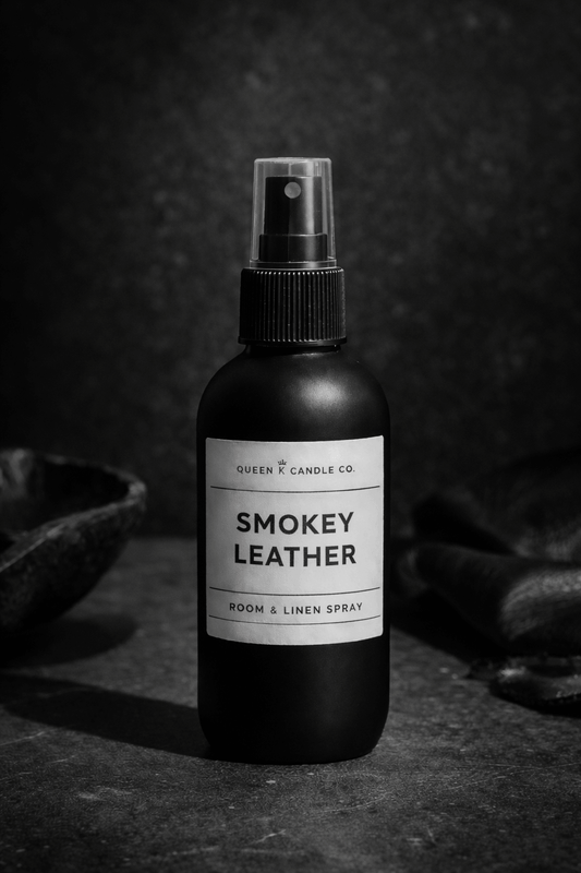Black room spray bottle labeled 'Smokey Leather' on a dark background