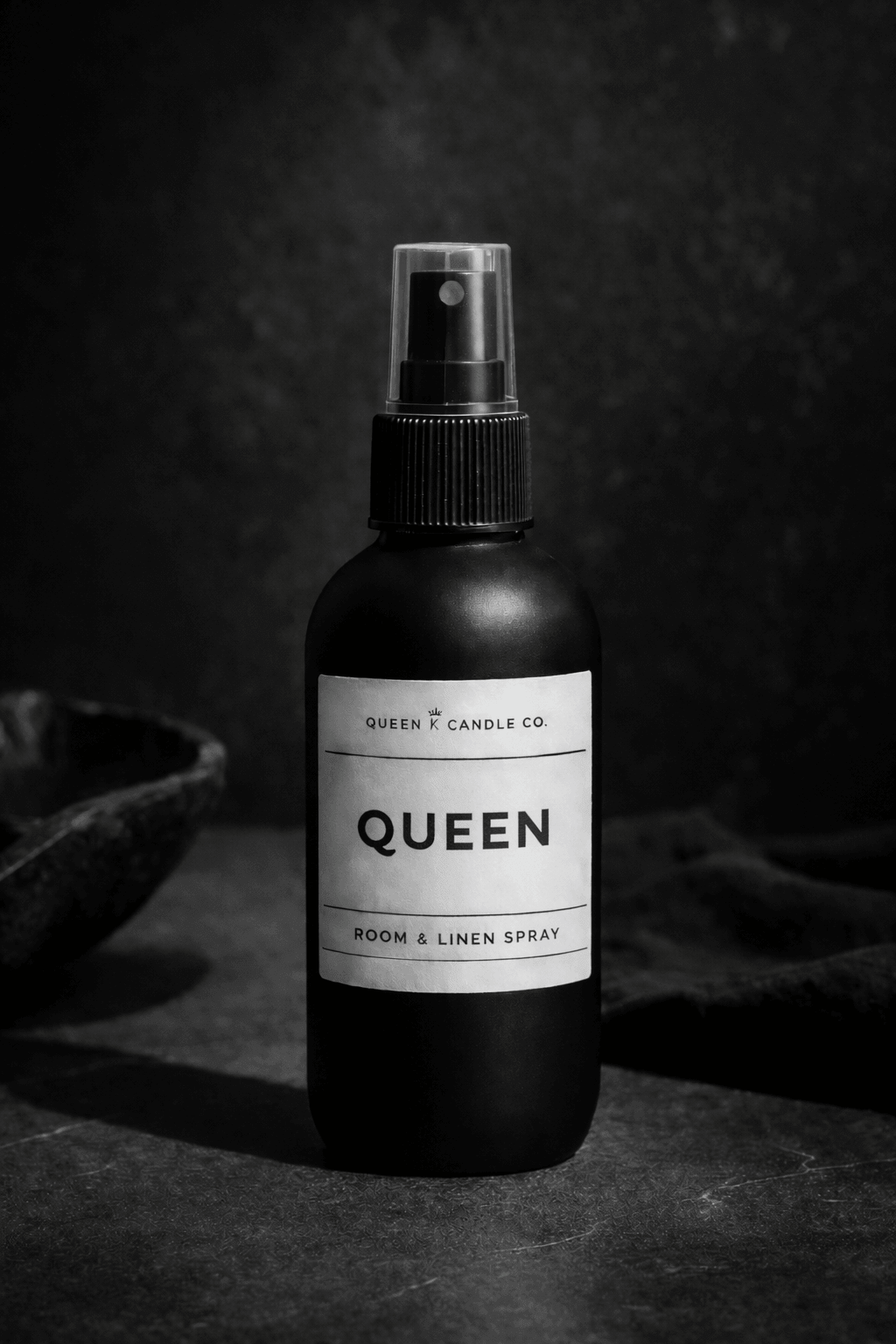 Black bottle of Deluxe Bourbon room & linen spray on a dark background