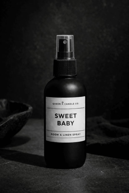 Black room spray bottle labeled 'Sweet Baby' on a dark background
