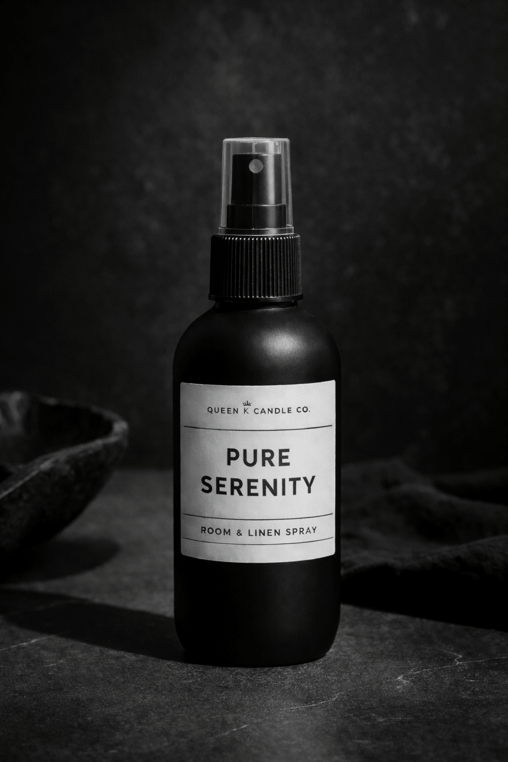 Black room & linen spray bottle labeled 'Luxurious Linen' on a dark background