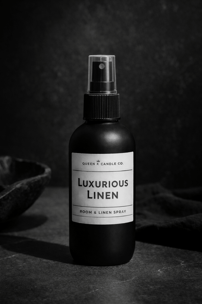 Black room & linen spray bottle labeled 'Luxurious Linen' on a dark background