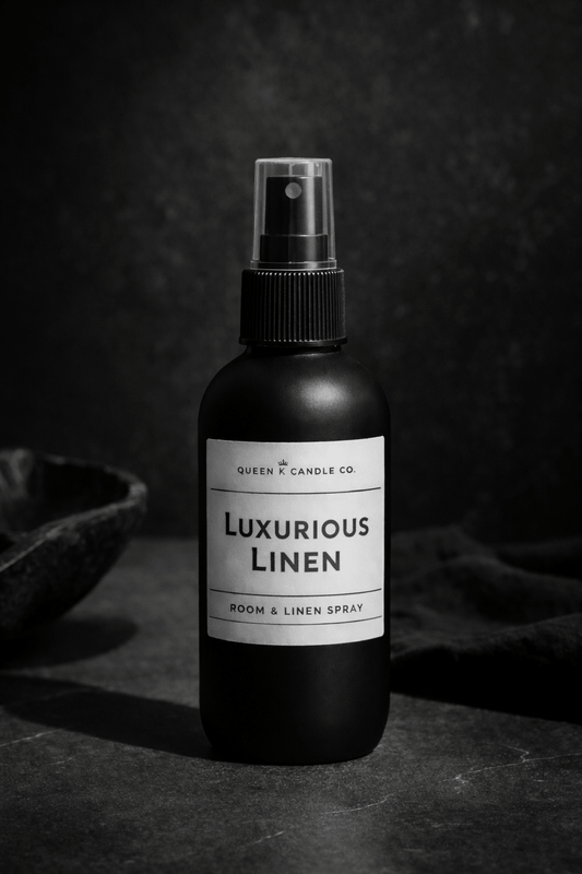 Black room & linen spray bottle labeled 'Luxurious Linen' on a dark background