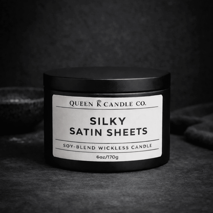Black candle jar with 'Silky Satin Sheets' label on a dark background