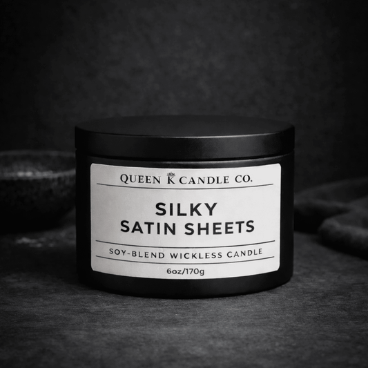 Black candle jar with 'Silky Satin Sheets' label on a dark background