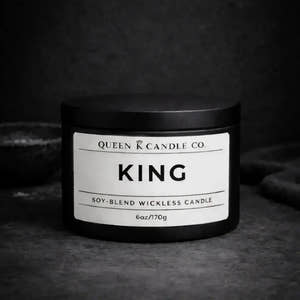Black candle jar labeled 'King' by Queen K Candle Co. on a dark background