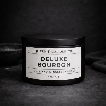 Black candle jar labeled 'Deluxe Bourbon' by Queen K Candle Co. on a dark background