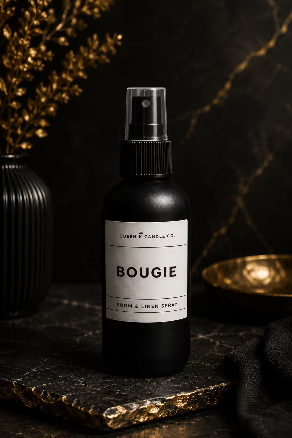 Black room and linen spray bottle labeled 'BOUGIE' on a dark surface with decorative elements.