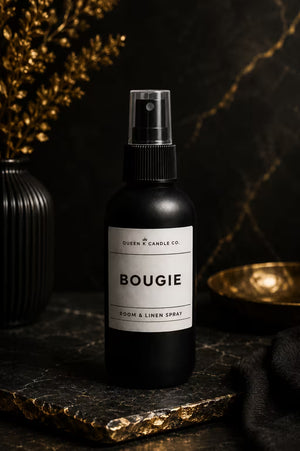 Black room and linen spray bottle labeled 'BOUGIE' on a dark surface with decorative elements.