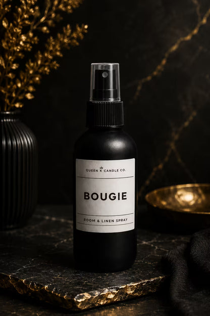 Black room and linen spray bottle labeled 'BOUGIE' on a dark surface with decorative elements.