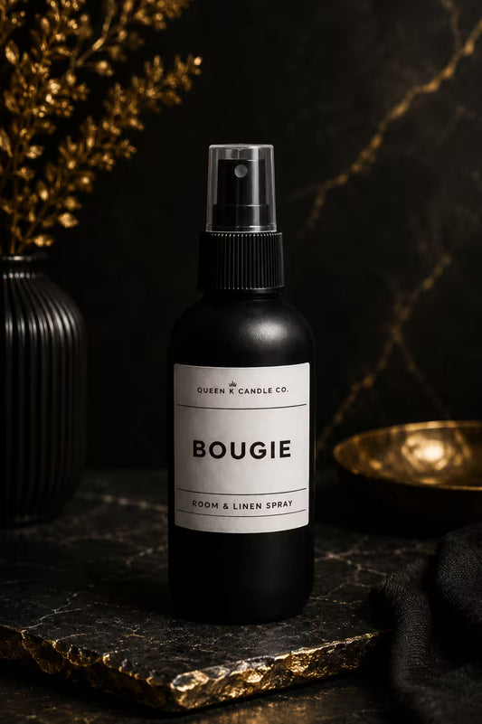 Black room and linen spray bottle labeled 'BOUGIE' on a dark surface with decorative elements.