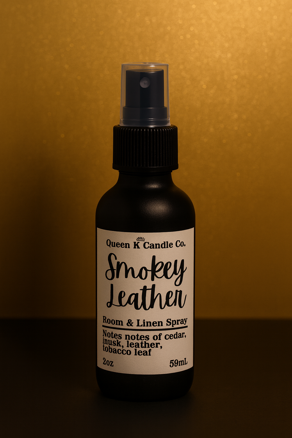 Room and linen spray bottle labeled 'Smokey Leather' by Queen K Candle Co. on a dark background.