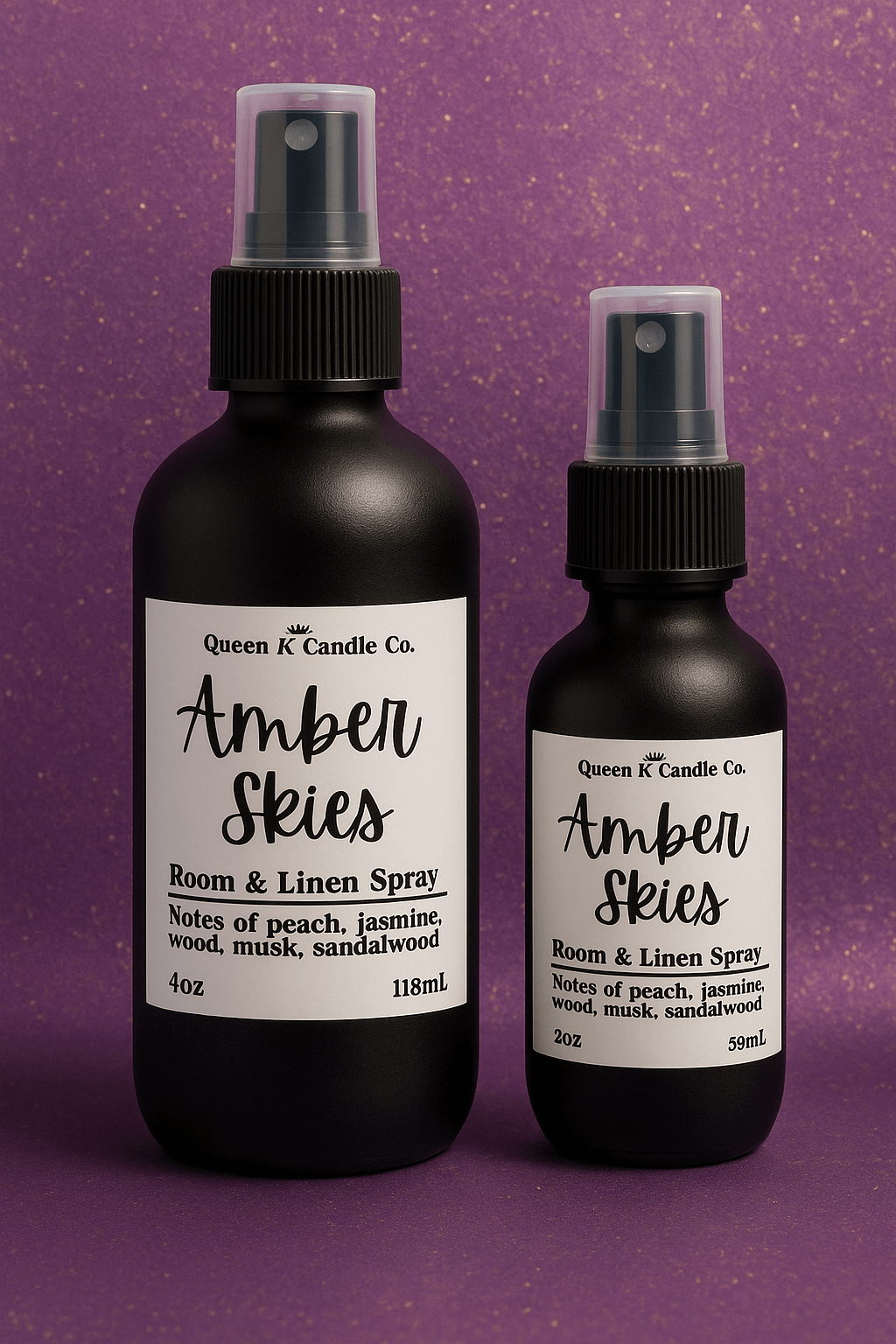 Two bottles of Queen K Candle Co. Amber Skies room and linen spray on a purple background