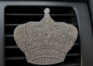 Decorative car air freshener shaped like a crown on a car vent.